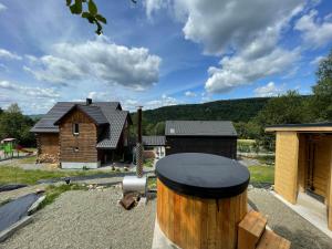 une maison avec un baril devant elle dans l'établissement Modrzewiowe Domki w Koszarawie, à Koszarawa