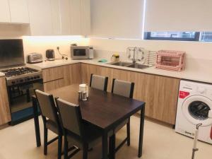 a kitchen with a table and chairs and a washing machine at Brown Stone Holiday Homes MH in Dubai