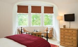 um quarto com uma cama com um cobertor vermelho em Coig na Shee Guest House em Newtonmore