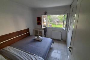 a small bedroom with a bed and a window at Sunny apartment with garden in Chios in Chios