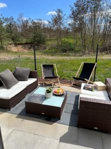 a patio with two couches and two chairs at Apartament nad jeziorem in Pszczew