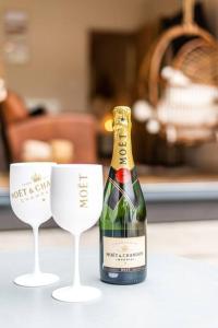 a bottle of champagne and two wine glasses on a counter at NEW Gingerbread Lodge of Tranquility in Torquay