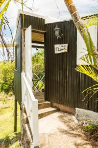 Rodrigues Island的住宿－Fantaisie Lodges，一座黑色的小建筑,门上有一个标志