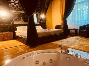 a bathroom with a bath tub and a bedroom at Cetate Residence in Braşov