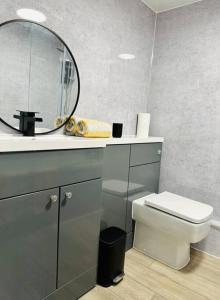 uma casa de banho com um WC branco e um espelho. em Flat in Cheltenham em Cheltenham