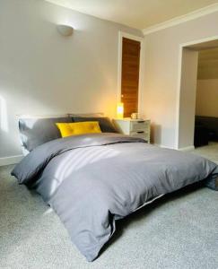 um quarto com uma cama grande e almofadas amarelas em Flat in Cheltenham em Cheltenham