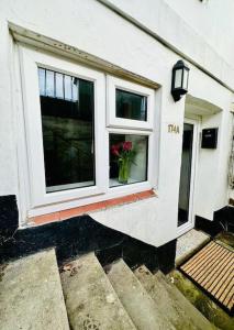 uma casa com uma janela com um vaso de flores em Flat in Cheltenham em Cheltenham