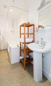 uma casa de banho com um lavatório e uma banheira em Coig na Shee Guest House em Newtonmore