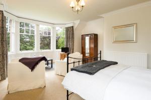 um quarto com uma cama branca e uma janela em Coig na Shee Guest House em Newtonmore