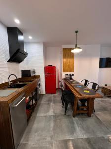 eine Küche mit einem Tisch und einem roten Kühlschrank in der Unterkunft Alojamientos Rías Baixas - Mares del Forte- Cangas in Cangas