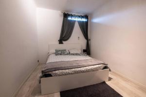 Dormitorio pequeño con cama y ventana en appart cosy,calme à 2 pas du centre de montbrison, en Montbrison