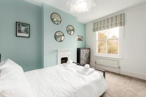 a bedroom with a white bed and a window at Beautiful Edwardian Central Oxford home in Oxford