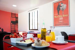 una mesa con un plato de comida y zumo de naranja en Casual del Teatro Madrid en Madrid