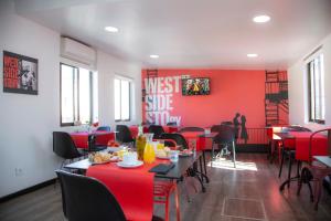 ein Esszimmer mit roten Wänden, Tischen und Stühlen in der Unterkunft Casual del Teatro Madrid in Madrid