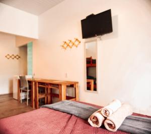 a hotel room with a bed with towels on it at Vila Capininga Ecopousada in Santo Amaro