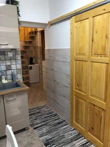 a kitchen with a large wooden door in a room at Móra apartman 3. in Kiskunfélegyháza