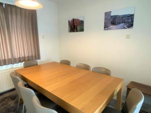 uma sala de conferências com uma mesa de madeira e cadeiras em Karen - 1st floor, Duinlaan 5b em Cadzand
