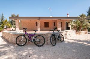 zwei Fahrräder stehen neben einer Ziegelmauer. in der Unterkunft Chez-Antoinette in Castel del Monte