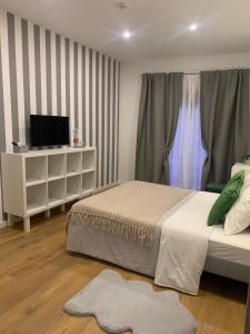 a bedroom with a bed and a tv on a cabinet at Largo da Rainha, Guesthouse in Merciana