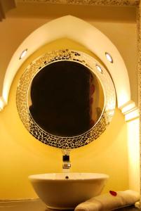 a bathroom sink with a mirror on a wall at Hotel Riad Todos in Marrakesh