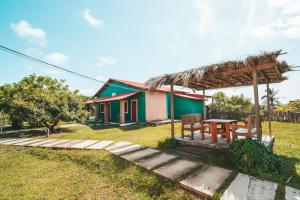 a house with a picnic table in front of it at Vila Capininga Ecopousada in Santo Amaro