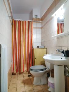 a bathroom with a toilet and a sink at Adorable Apartment in the center in Volos