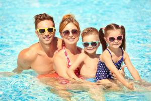 a family in the water at a swimming pool at 8 Berth Caravan With Decking And Wifi At Broadland Sands Park Ref 20064Cf in Hopton on Sea