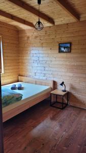 a large bed in a wooden room with a table at Na Równej Bieszczady in Polańczyk