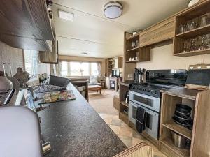 a kitchen with a stove and a counter top at Lovely Caravan With Decking And Free Wifi In Lowestoft Ref 12106b in Lowestoft