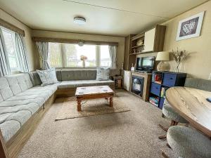 a living room with a couch and a coffee table at Lovely Caravan With Decking And Free Wifi In Lowestoft Ref 12106b in Lowestoft