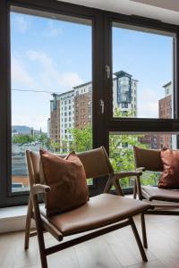 two chairs sitting in a room with windows at Wilton House Belfast Serviced Apartments in Belfast