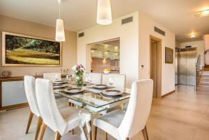une salle à manger avec une table et des chaises blanches dans l'établissement Deluxe Maisonette With Shared Pool 2#, à Anavyssos