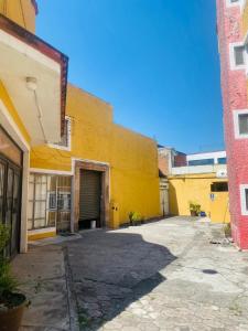un edificio amarillo con un garaje en el medio en Hotel Tres Torres en Morelia