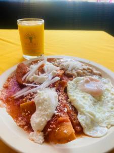 un plato de comida con huevos fritos y un vaso de cerveza en Hotel Tres Torres en Morelia