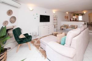 a living room with two white couches and a tv at Windmill by OCvillas in Albufeira