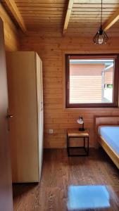 ポランチクにあるNa Równej Bieszczadyのベッド、窓、冷蔵庫が備わる客室です。