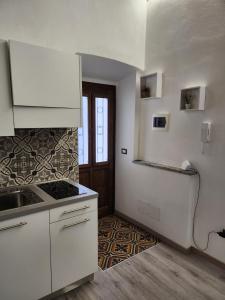 a kitchen with white cabinets and a counter top at Mansarde & Suite Maison 1706 Lago Orta in Borgomanero