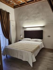 een slaapkamer met een groot bed in een kamer bij Mansarde & Suite Maison 1706 Lago Orta in Borgomanero