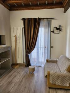 uma sala de estar com um sofá e uma janela em Mansarde & Suite Maison 1706 Lago Orta em Borgomanero