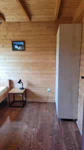 Zimmer mit einer Holzwand mit einem Tisch. in der Unterkunft Na Równej Bieszczady in Polańczyk