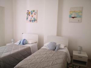 ein Schlafzimmer mit 2 Betten und einem Bild an der Wand in der Unterkunft PESCIOLINO B&B in Mola di Bari