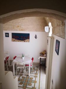 ein Esszimmer mit einem weißen Tisch und Stühlen in der Unterkunft PESCIOLINO B&B in Mola di Bari