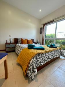 a bedroom with a bed and a large window at Mindelo Beach House in Vila Chã