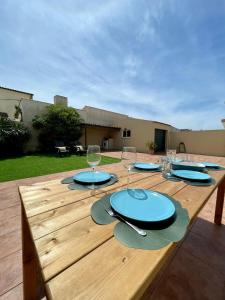 una mesa de madera con platos y copas de vino. en Mindelo Beach House, en Vila Chã