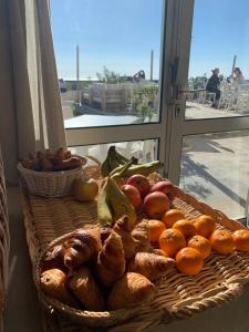 una cesta de pan y fruta en una mesa en hôtel Le Grand Large, en Gruissan