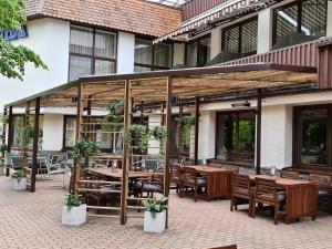 an outdoor patio with wooden tables and chairs at Apartamentai NIDA in Nida