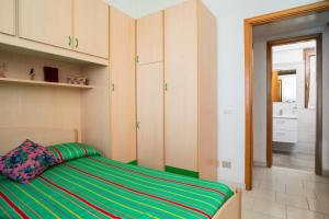 a bedroom with a bed with a green and yellow stripes at Casa Vacanza Vista Mare in SantʼAlessio Siculo