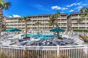 a resort with a swimming pool with chairs and umbrellas at Ocean Dunes Villa 404, 2 Bedroom, Ocean Front, Pool, Sleeps 6 in Hilton Head Island