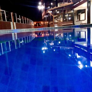 an empty swimming pool at night with lights at Hotel Porto Brasília in Porto Seguro