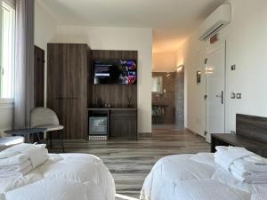 パドヴァにあるRoyal Garden luxury roomsのベッドルーム1室(ベッド2台、壁にテレビ付)